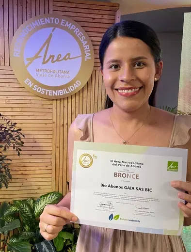 Integrante de Bio Abonos GAIA con el certificado del Reconocimiento Empresarial en Sostenibilidad del Área Metropolitana